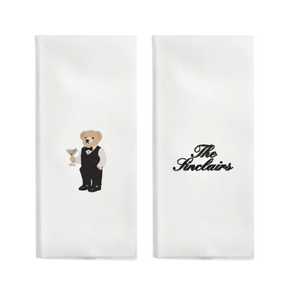Two white napkins with a teddy bear and 'The Stelains' logo on a white background